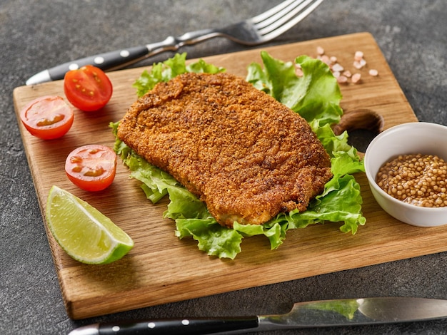 Cotoletta di maiale impanata con pomodorini senape e limone