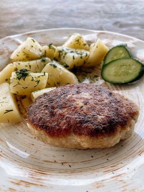 Cotoletta di pesce con patate e verdure. cotoletta di luccio con erbe e verdure