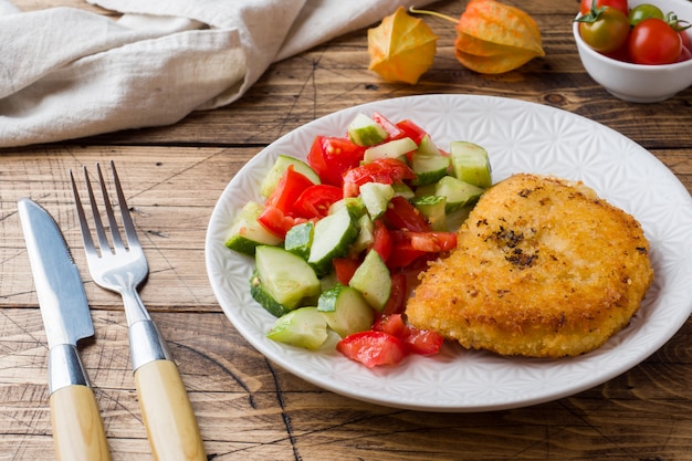 Cotoletta di pollo e insalata di cetrioli con pomodori