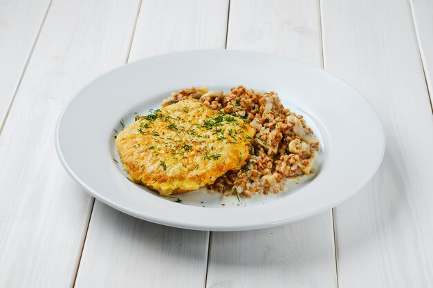 Cotoletta di pollo in panatura con grano saraceno e funghi