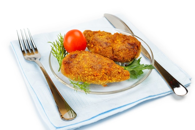 Cotoletta di pollo su un tovagliolo blu. Servire con coltello e forchetta.