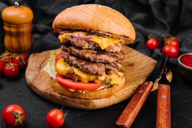 Cotoletta gigante degli alimenti a rapida preparazione dell'hamburger sulla tavola di legno