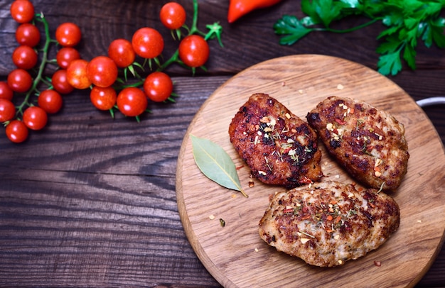 Cotolette con spezie su una tavola di cucina in legno