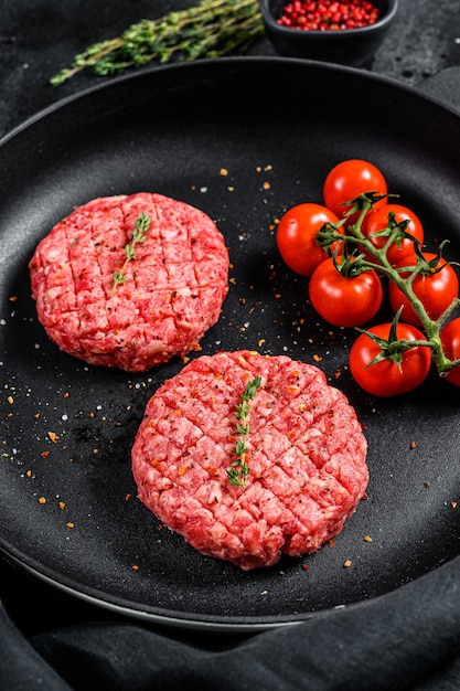Cotolette crude della bistecca dell'hamburger della carne della carne tritata in una pentola. Vista dall'alto