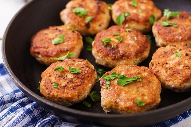 Cotolette deliziose succose della carne in pentola su una tavola di legno.