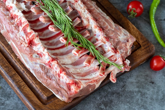 cotolette di agnello cotolette d'agnello fresche intere o costole su sfondo scuro prodotti di macellazione da vicino