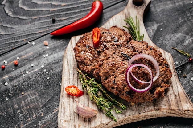 Cotolette di carne fresca su sfondo di legno bistecca di manzo su una griglia per barbecue Vista dall'alto in formato banner lungo