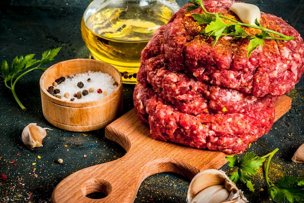 Cotolette di hamburger crudo con sale, pepe, olio, erbe e spezie