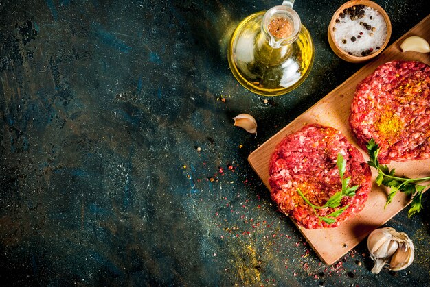 Cotolette di hamburger crudo con sale, pepe, olio, erbe e spezie