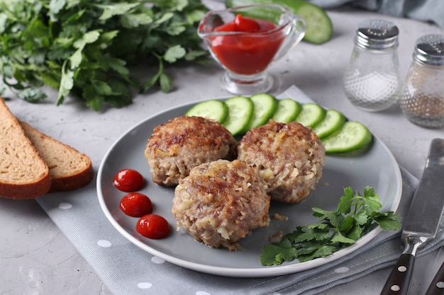 Cotolette di manzo servite con cetriolo e salsa di pomodoro