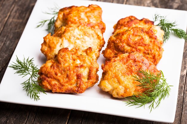 Cotolette di pollo con aneto in un piatto bianco sul tavolo