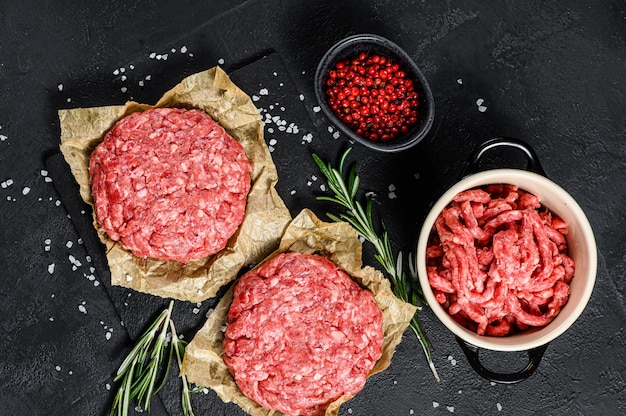 Cotolette e condimenti crudi della bistecca dell'hamburger della carne della carne tritata. Fattoria biologica di carne. Vista dall'alto