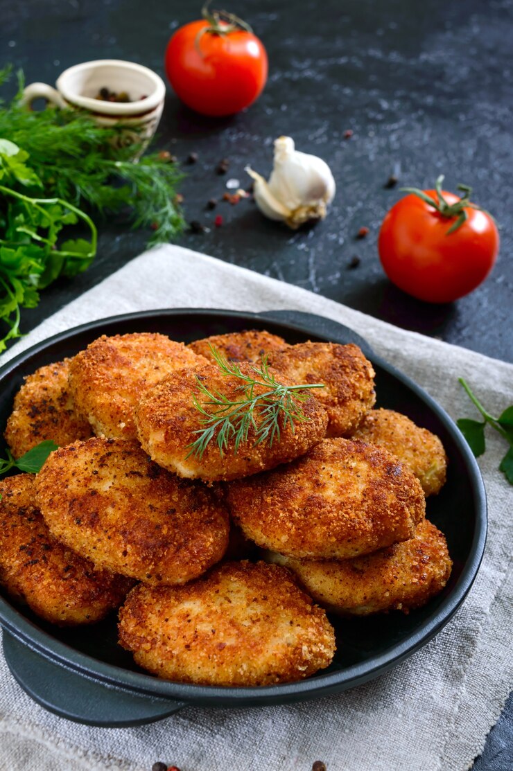 Cotolette fatte in casa succose (manzo, maiale, pollo) su uno sfondo nero.