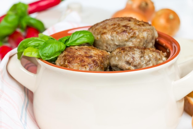 Cotolette fritte con foglie di basilico cipolle e peperoni