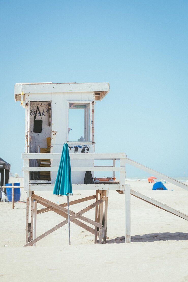 Foto cotta di soccorritore sulla spiaggia contro un cielo blu limpido