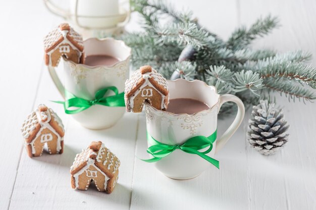 Cottage di pan di zenzero fatti in casa con cioccolata calda per Natale