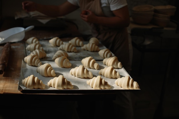 Cottura dei croissant Teglia con croissant pronti da cuocere in forno