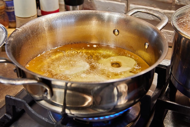 Cottura della frittella di mele Ciambella di mele in olio bollente