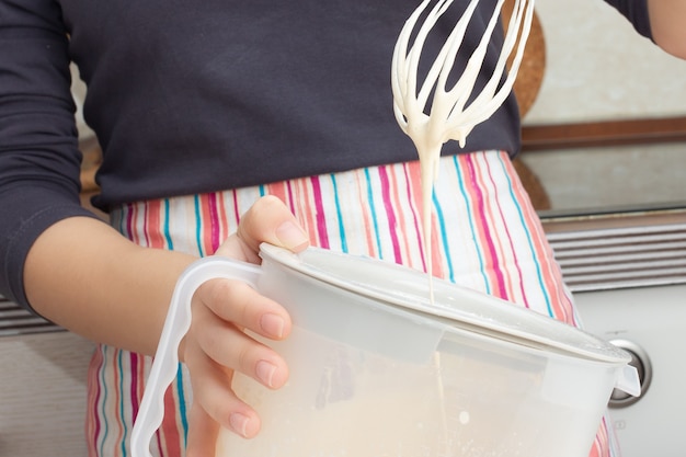 Cottura della pasta. Ragazza frusta con un mixer