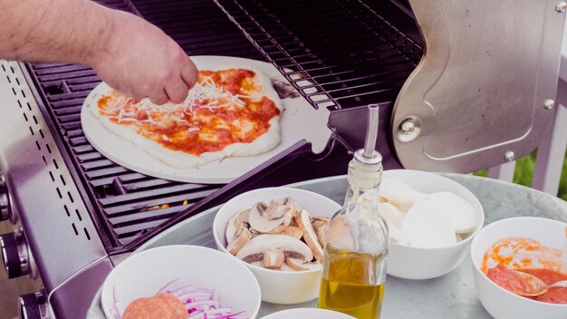 Cottura della pizza sul grill a gas all'aperto.