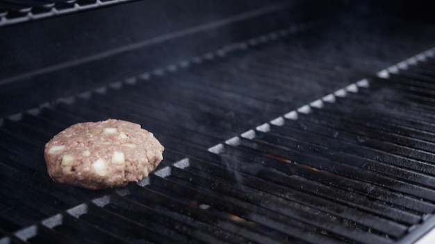 Cottura di polpette di manzo hamburger su una griglia a gas.