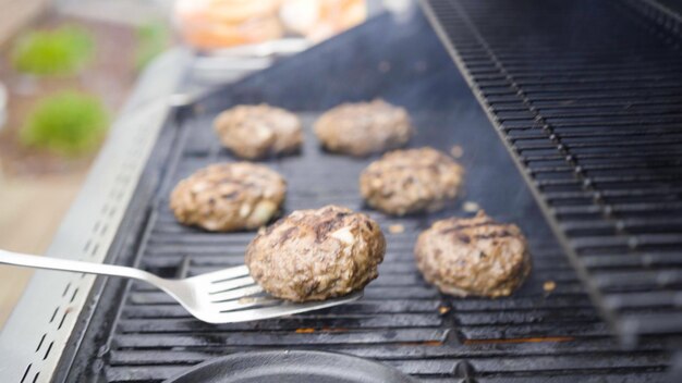 Cottura di polpette di manzo hamburger su una griglia a gas.