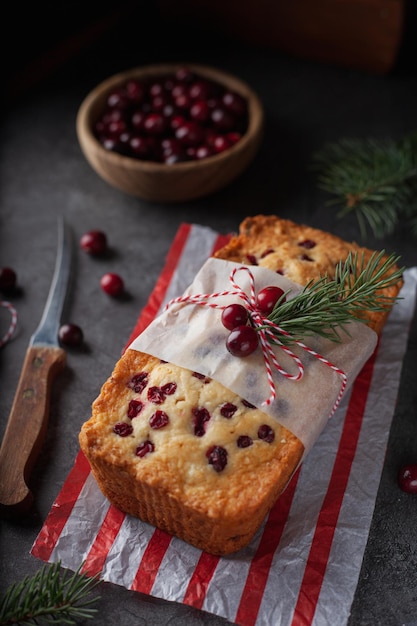 Cottura natalizia con bacche rosse su fondo nero Torta natalizia con mirtilli rossi decorati