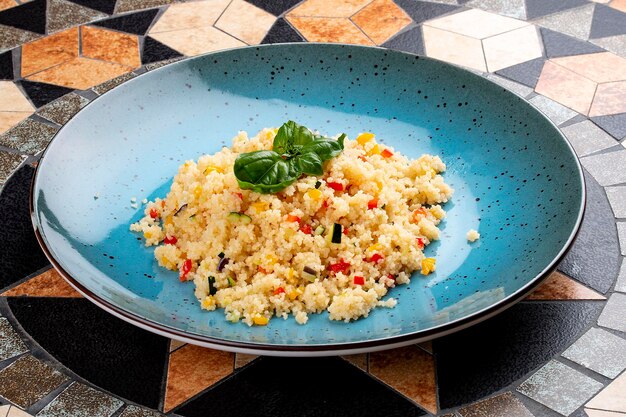 Cous cous con verdure in un piatto decorativo in ceramica