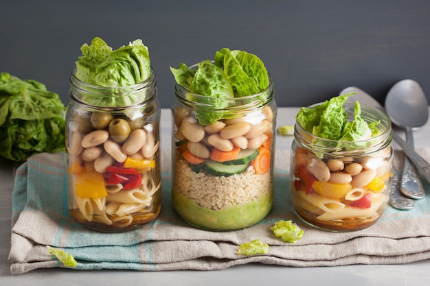 Couscous vegano e insalata di pasta in barattoli di vetro con fagioli di verdure