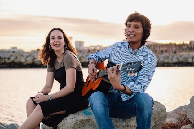 Coverband coppia di musicisti suona la chitarra acustica e canta vicino alla spiaggia. Mare sullo sfondo