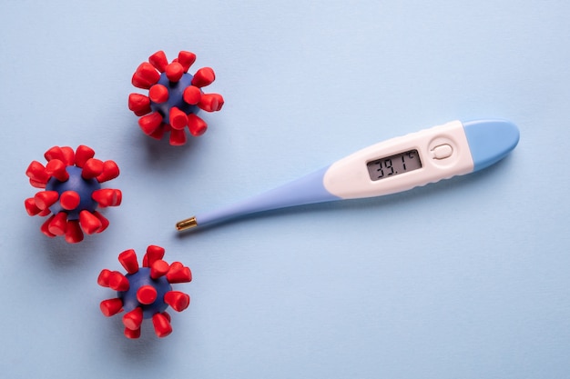 COVID-19, concetto di Coronavirus. Termometro elettronico e modelli di virus covid-19