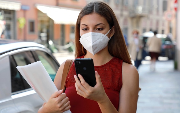 COVID-19 Crisi economica globale Donna disoccupata con maschera che utilizza un telefono cellulare e consegna curriculum vitae