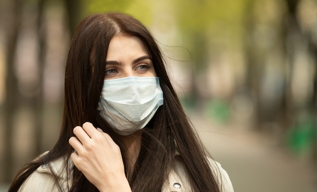 COVID-19 Pandemia Coronavirus Donna sulla strada della città che indossa una maschera protettiva per la diffusione del virus della malattia. Ragazza con maschera protettiva sul viso contro la malattia di Coronavirus 2019.