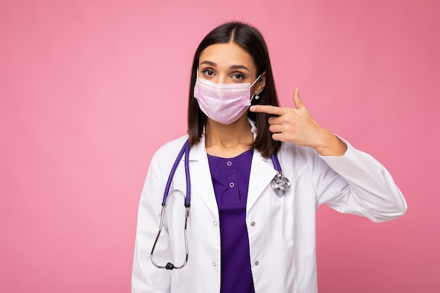 Covid19, coronavirus, concetto di assistenza sanitaria e medici. Foto di un giovane medico europeo professionista fiducioso in maschera medica e camice bianco, stetoscopio sul collo, paziente pronto ad aiutare, combattere la malattia