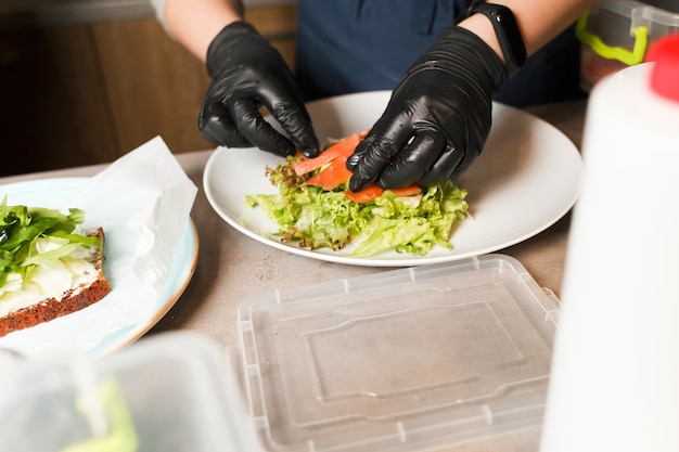 Covone che produce insalata di verdure con il salmone affumicato in ristorante.