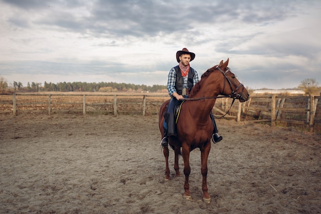 Cowboy a cavallo in un ranch