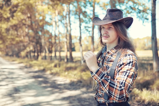 Cowboy con cappello in un campo in autunno