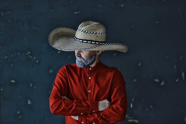 cowboy severo con un cappello con tesa, paglia, stile vintage retrò, uomo arrabbiato selvaggio west western