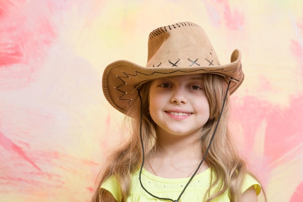 Cowgirl. bambina in cappello da cowboy su sfondo colorato, copia spazio