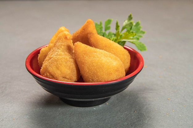 Coxinha fritto tradizionale nel piatto su sfondo ardesia popolare spuntino brasiliano