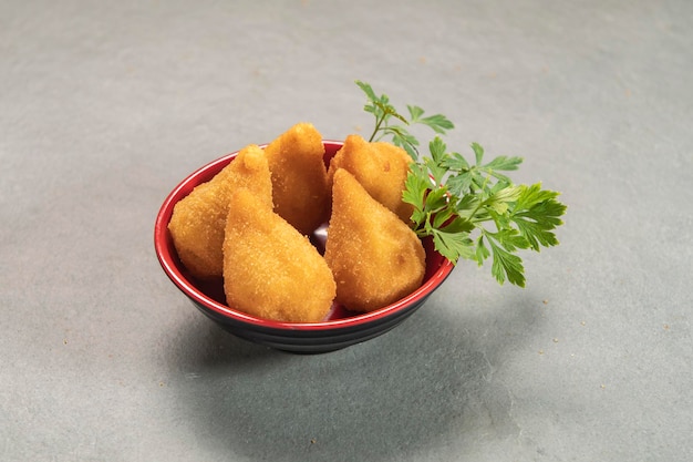 Coxinha fritto tradizionale nel piatto su sfondo ardesia popolare spuntino brasiliano