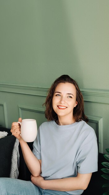 Cozy Tea Time Ritaglio della vista di una donna che si gode il tè sul divano del soggiorno Scena domestica rilassata Unw
