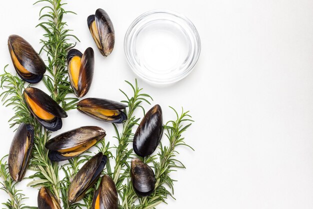 Cozze al rosmarino sul tavolo. Acqua in una ciotola di vetro. Lay piatto