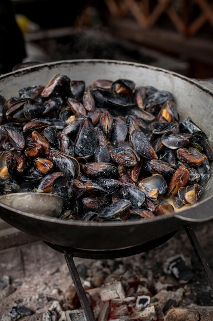 Cozze al vapore Cozze fresche alla griglia Un sacco di gusci di cozze che cuociono in una grande padella metallica