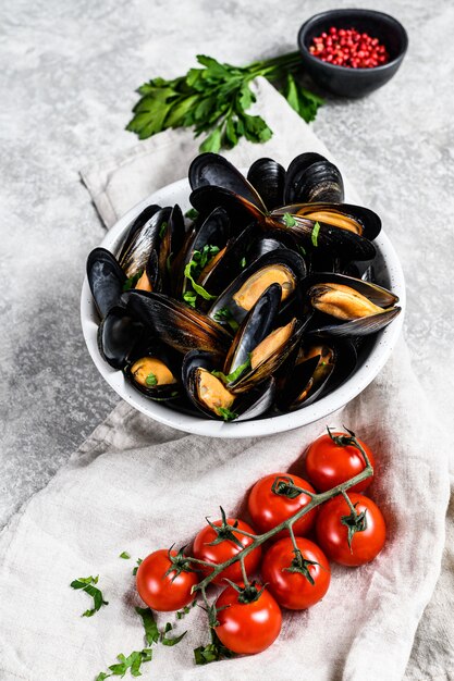 Cozze con erbe e salsa in ciotola. Graysurface