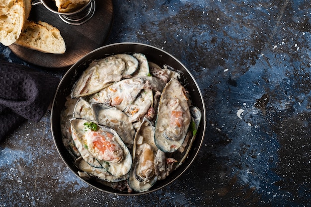 Cozze con salsa di formaggio blu e baguette all'aglio.