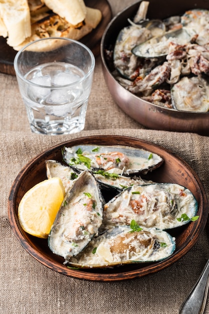 Cozze con salsa di formaggio blu e baguette all'aglio.