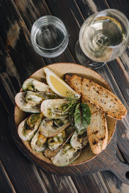 Cozze cotte in teglia con pane e bicchiere di vino bianco