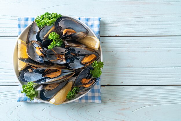 cozze fresche alle erbe in una ciotola con il limone