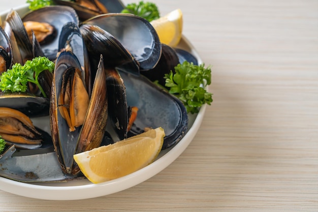 cozze fresche alle erbe in una terrina al limone